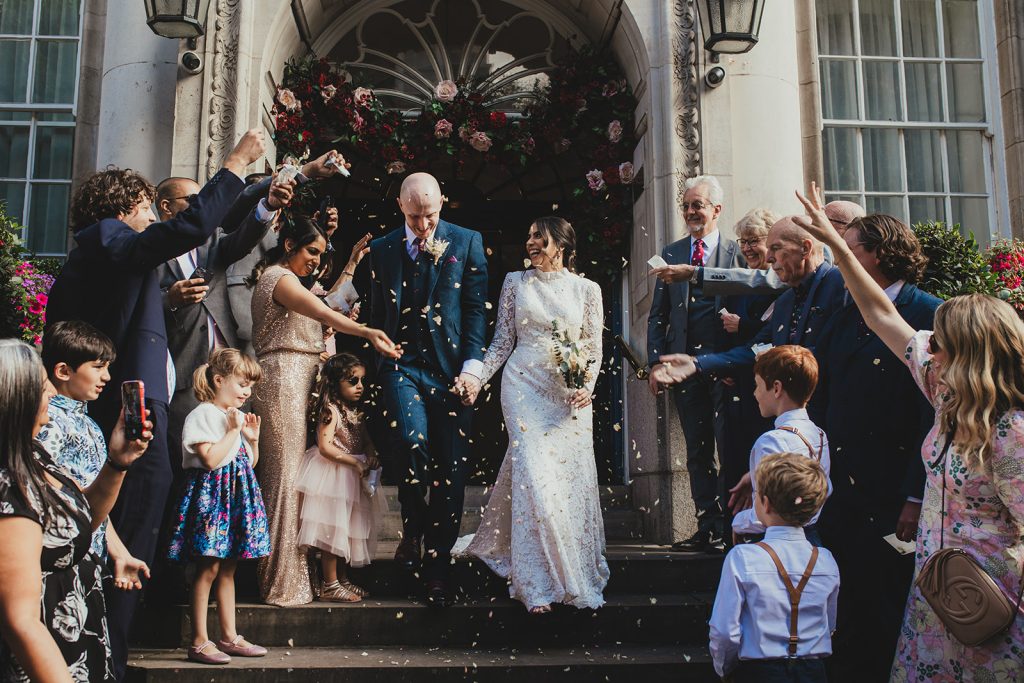 Couple leaving Chelsea Old Town Hall with confetti on the steps