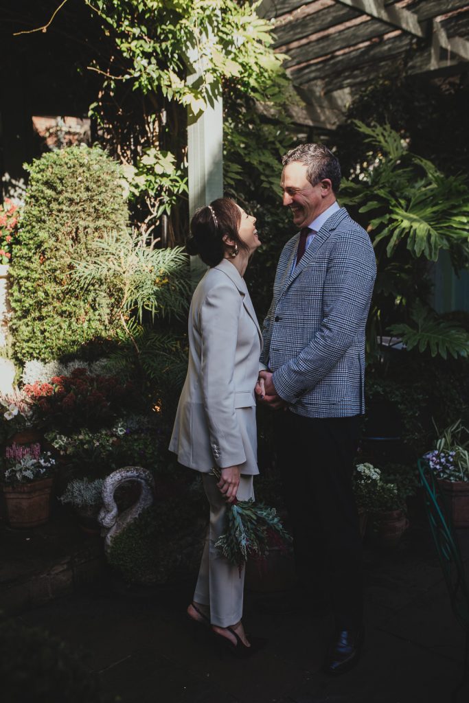 Couple laughing together in soft sunlight after their Chelsea Old Town Hall ceremony
