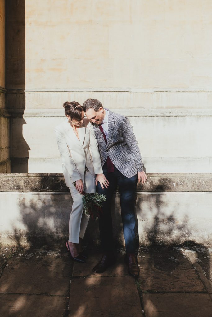 Couple laughing together in soft sunlight after their Chelsea Old Town Hall ceremony