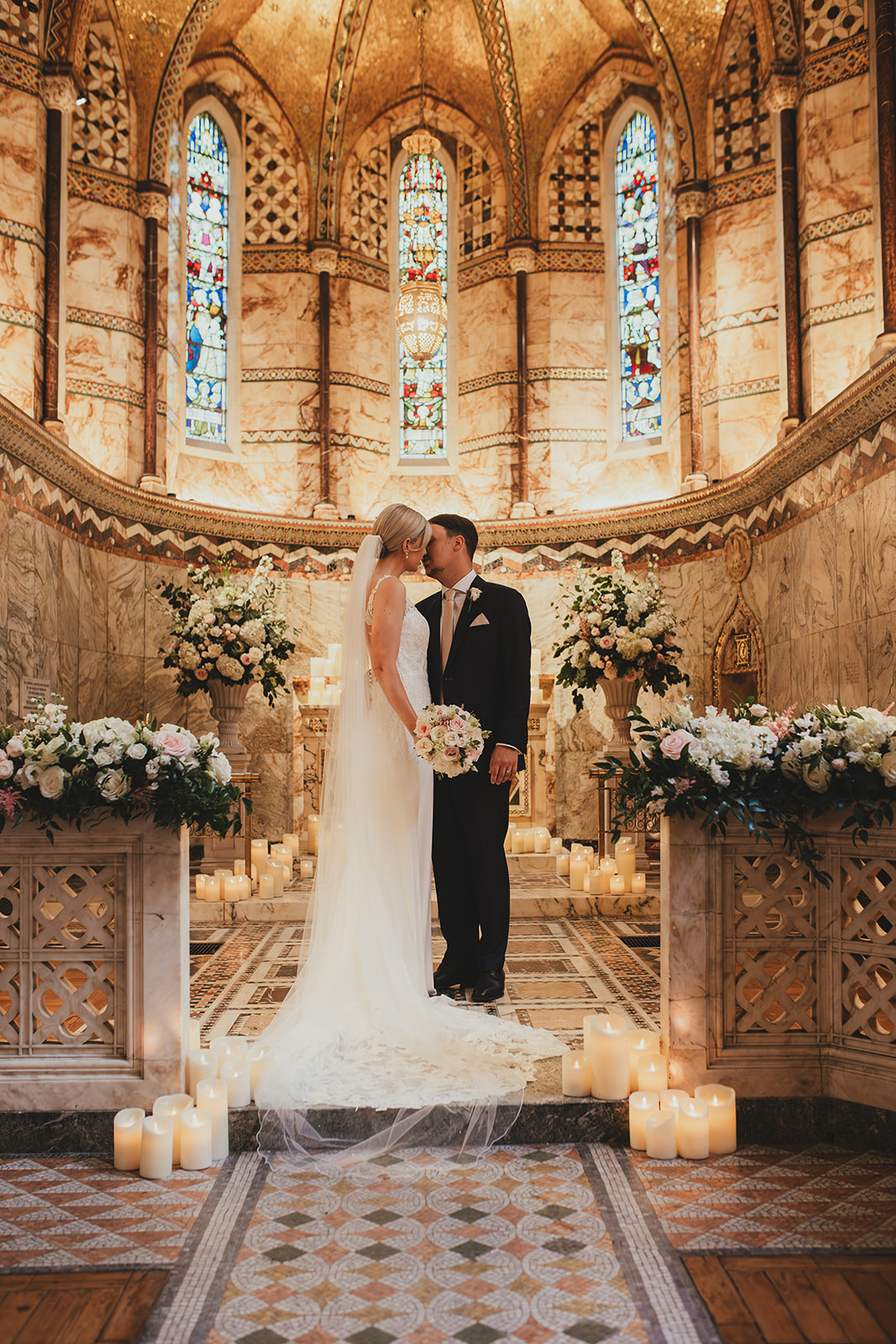 Bride and groom kissing at the alter in the Fitzrovia Chapel
