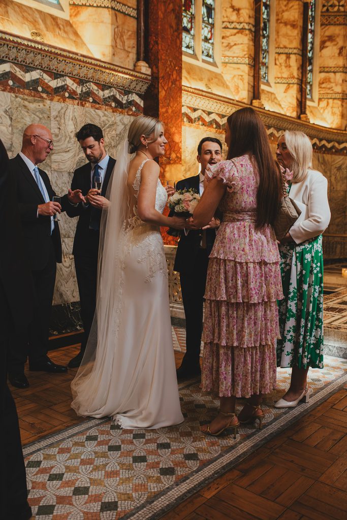Bride and groom mingling with guests in The Fitzrovia Chapel after wedding ceremony