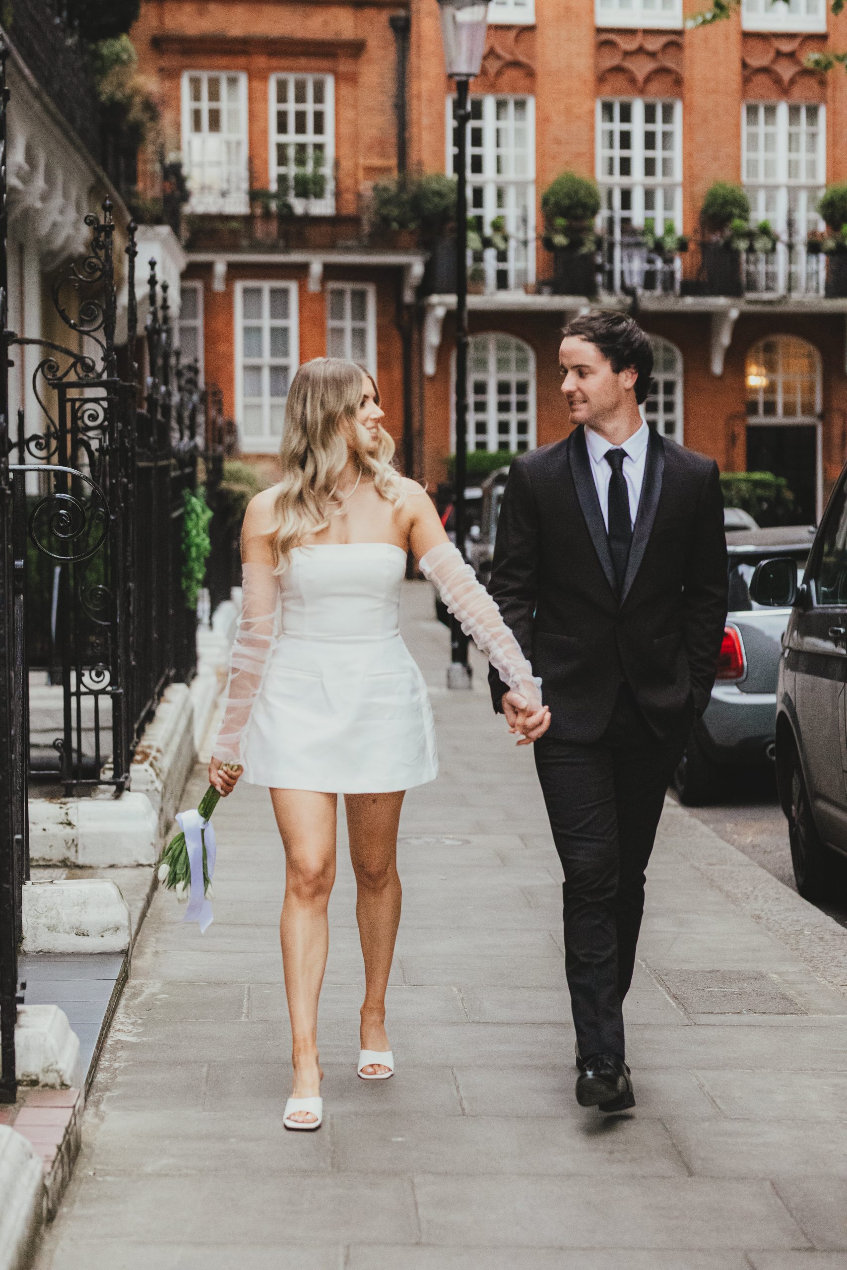 Bride and groom walking in London, candid editorial wedding photograph