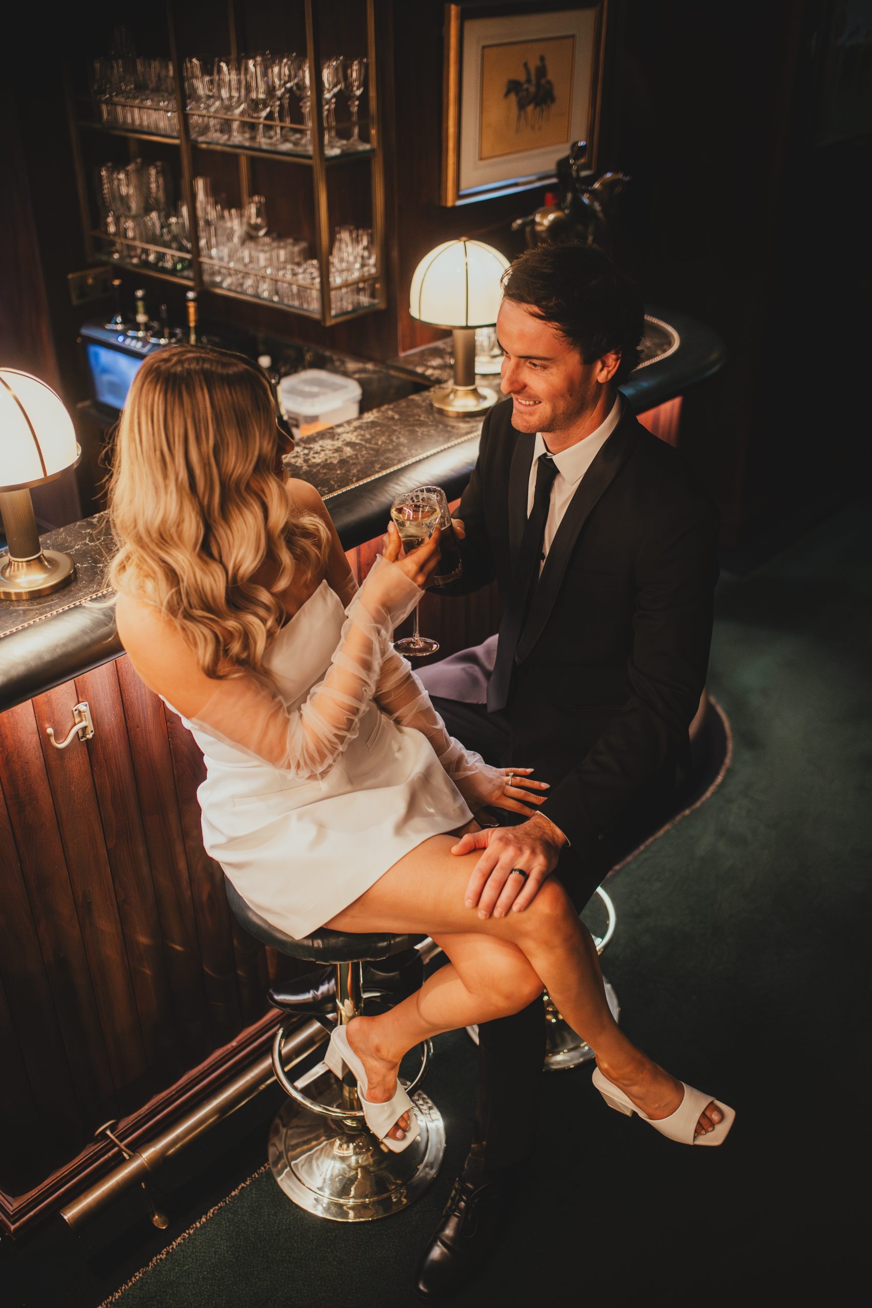 Couple celebrating with drinks in a London bar, modern elopement