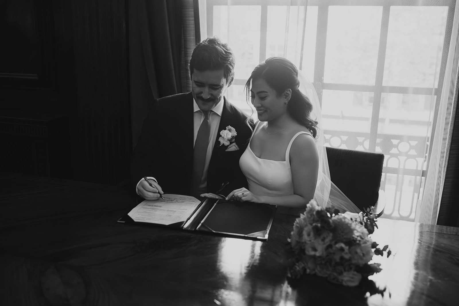 Bride and groom signing the register after the ceremony, Old Marylebone Town Hall