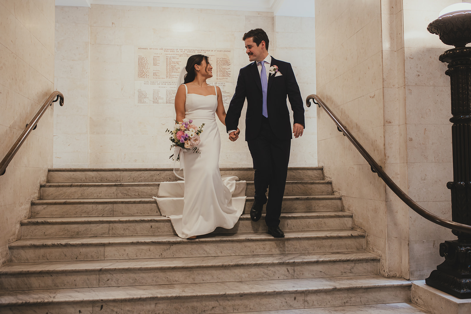 Bride and groom portrait on the steps inside Old Marylebone Town Hall