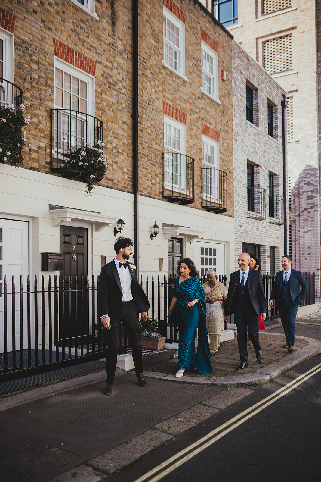 Family and wedding party walking together outside in London before the ceremony.
