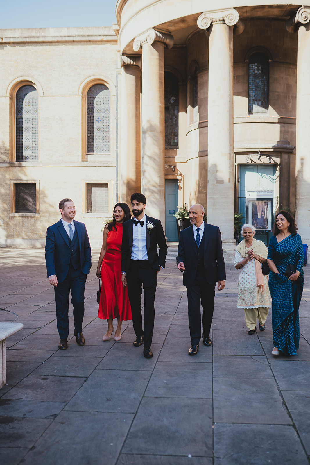 Wedding guests walking together along a London street towards the ceremony.