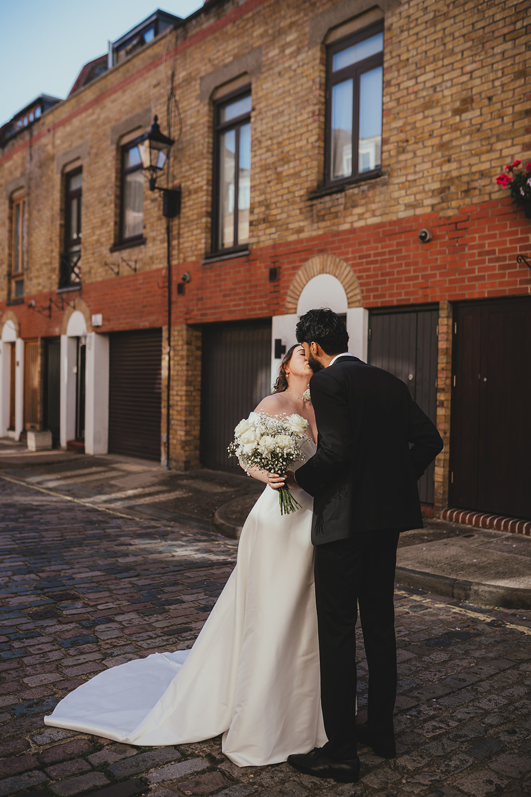 Bride smiling at the groom during their first look on a cobbled London mews