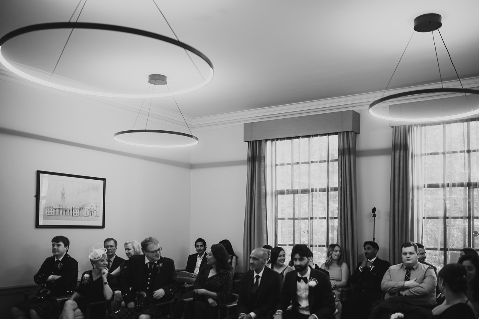 Black and white wide shot of guests seated in the Old Marylebone Town Hall ceremony room