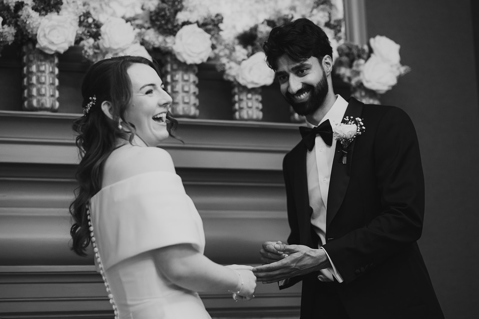 Black and white close-up of the couple laughing together during their Old Marylebone Town Hall ceremony