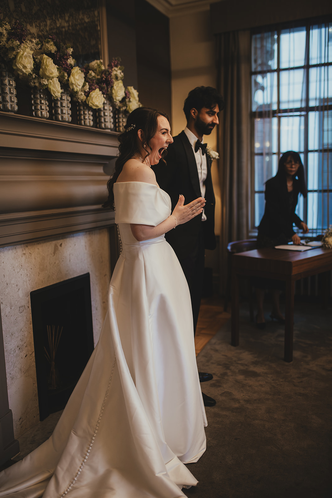Bride reacts with excitement during the ceremony in the Mayfair Room at Old Marylebone Town Hall