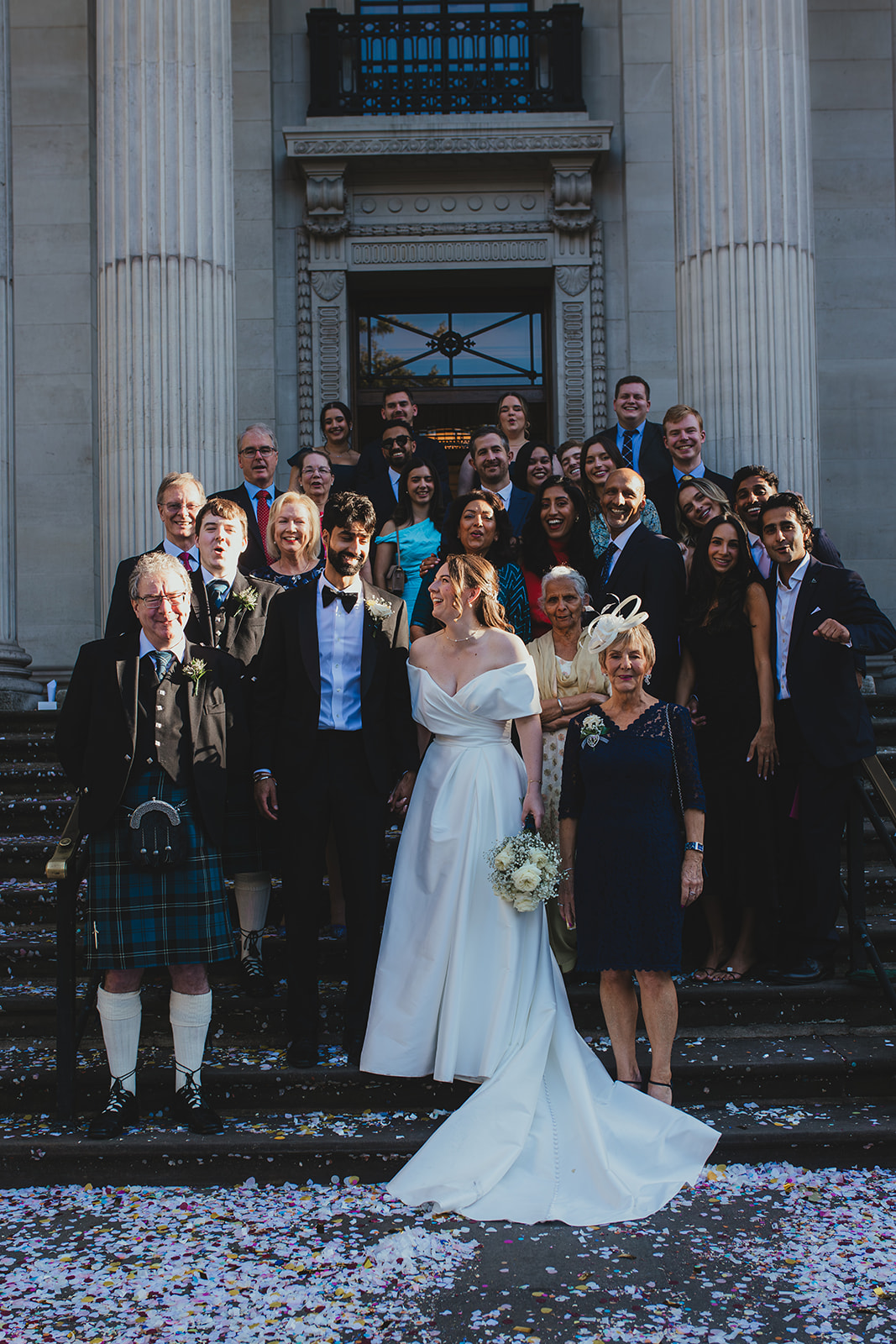 Whole wedding party portrait on the steps with the bride and groom at Old Marylebone Town Hall
