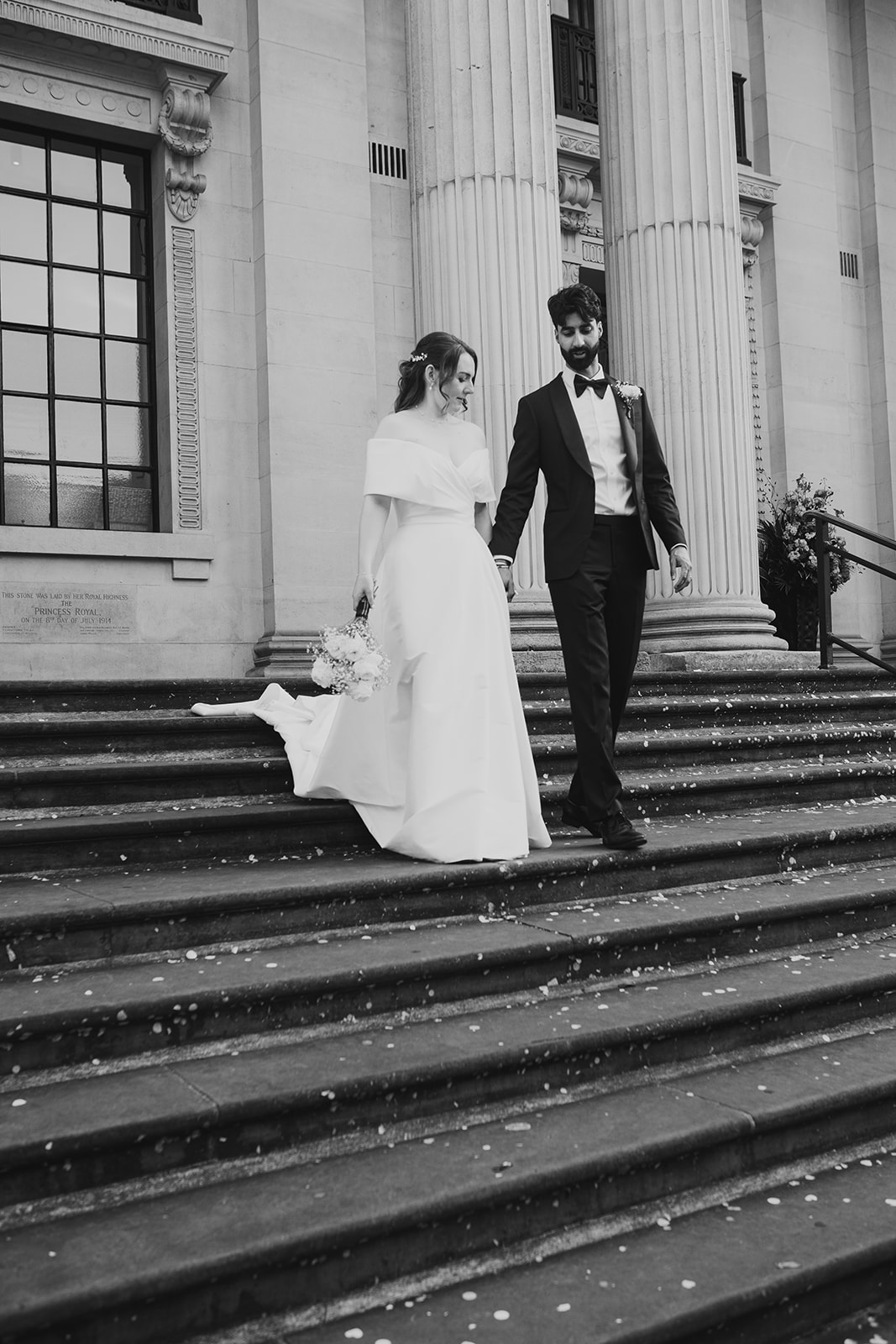 Bride and groom walk down the steps of Old Marylebone Town Hall, London