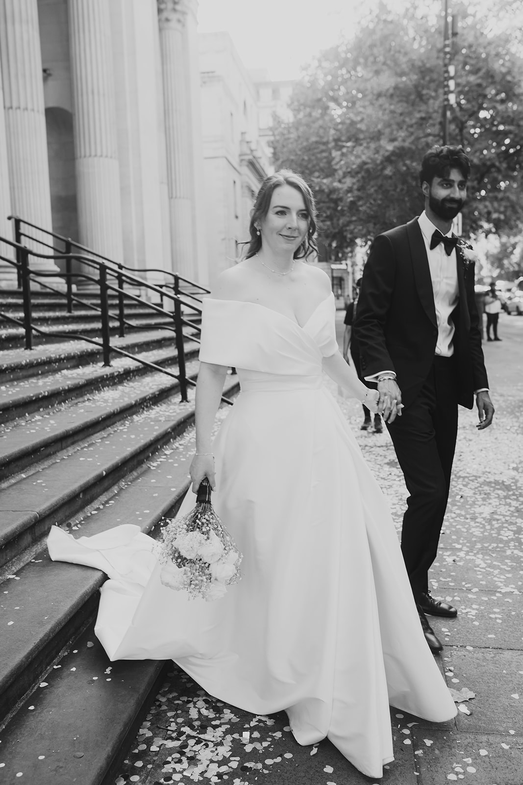Bride and groom walk down the steps of Old Marylebone Town Hall, London