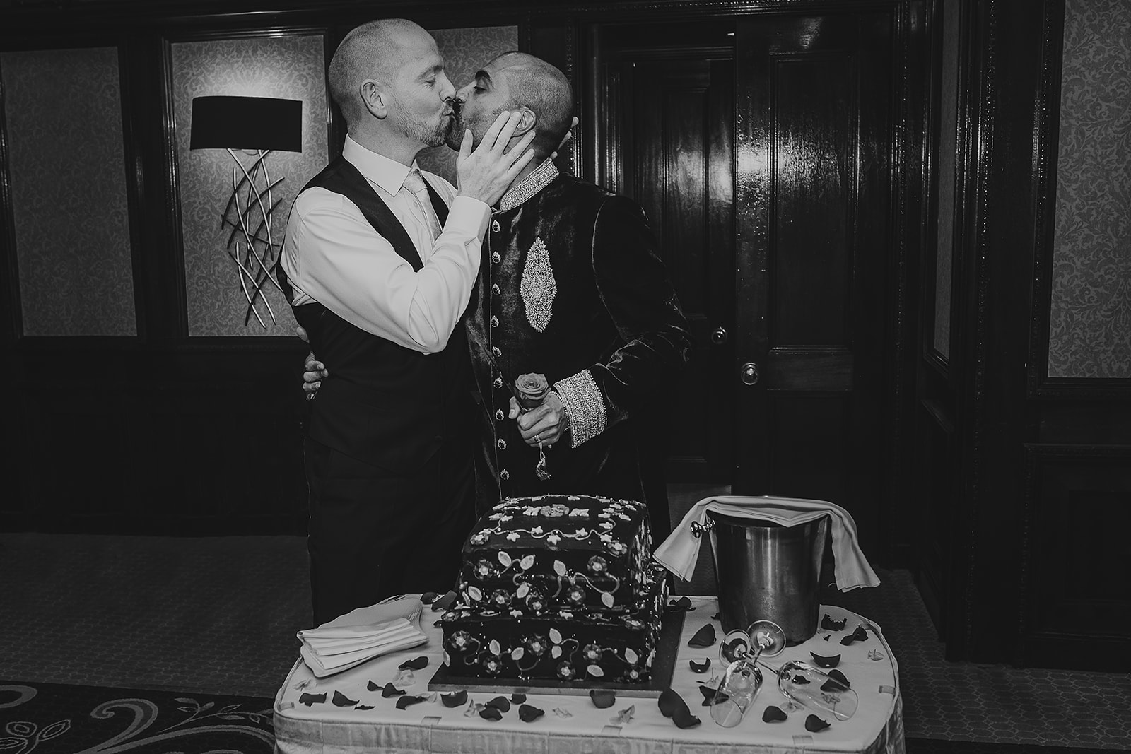 Groom and groom cutting wedding cake at reception at the Taj, London