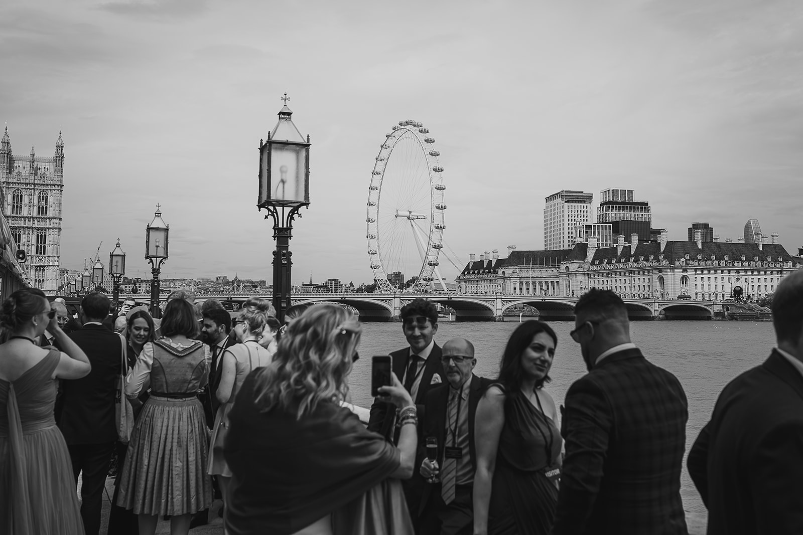 Scene of London skyline from balcony of Palace of Westminster with guests at wedding drinks reception