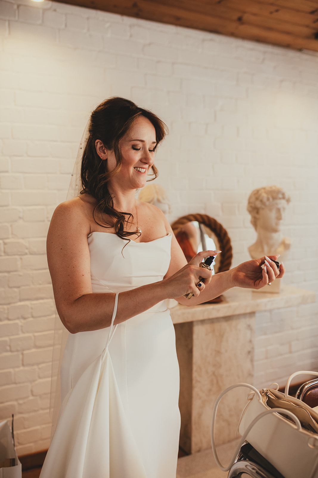 Bride getting ready spraying perfume, London wedding, Islington Town Hall wedding
