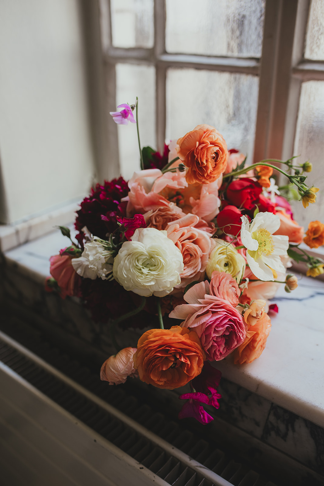 Wedding bouquet of oranges, reds and peach flowers, London wedding, Islington Town Hall