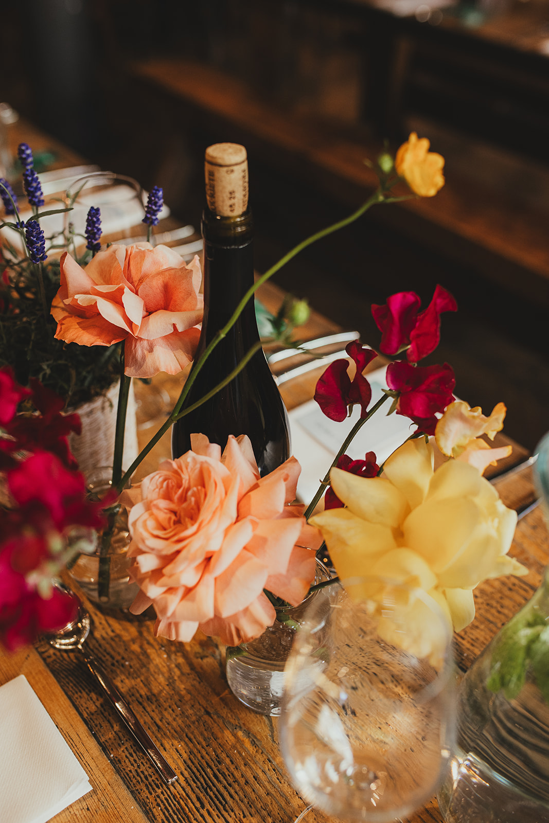 Orange red and peach flowers decorating tables at The Depot N7 wedding reception