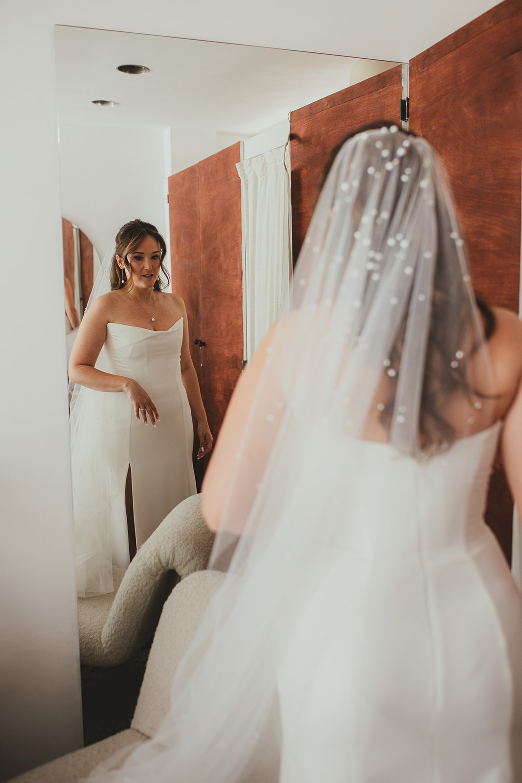 Bride getting into wedding dress looking into mirror, London wedding, Islington Town Hall wedding