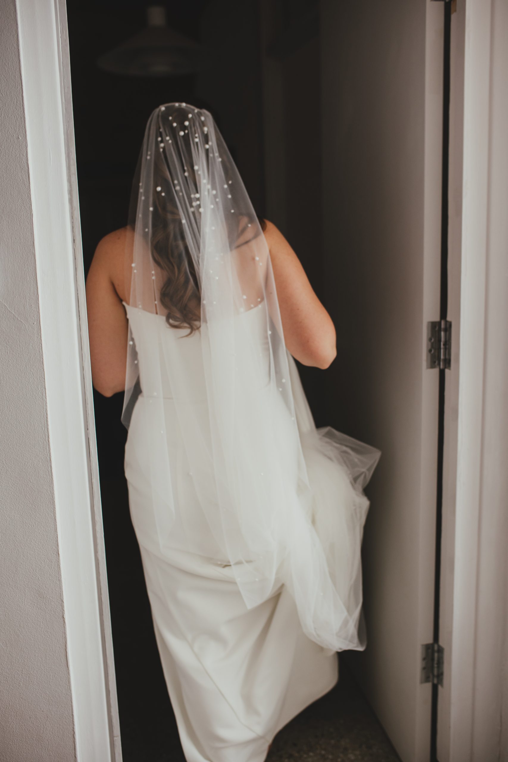 Detail phot of back of bride in her dress with veil, London wedding, Islington Town Hall wedding