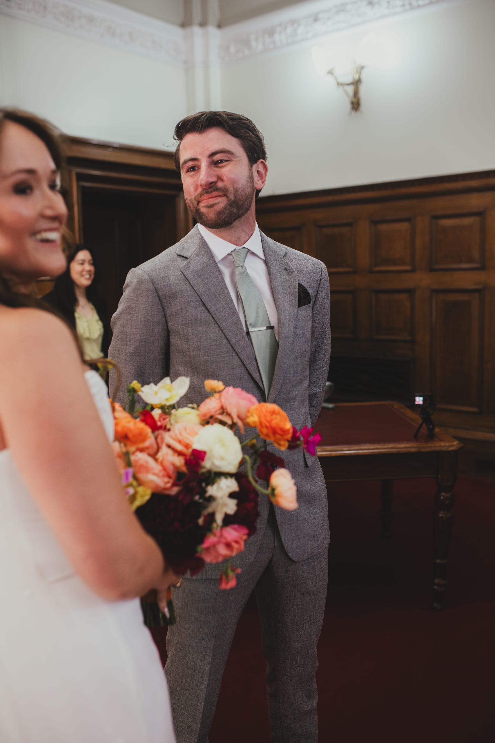 Groom looking at bride as she walks down the aisle at Islington Town Hall, London wedding