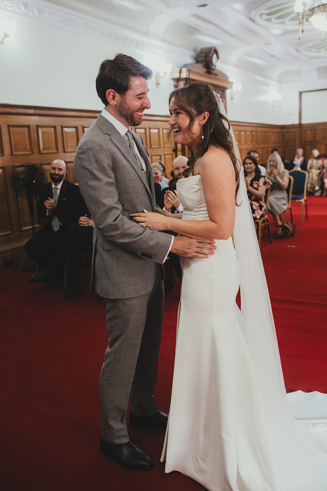 Bride and groom laughing during ceremony at Islington Town Hall, London wedding