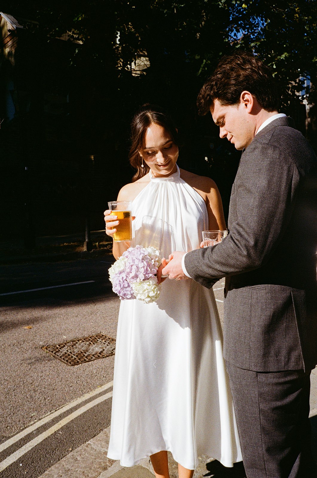 Bride and groom with pints outside pub in Hampstead