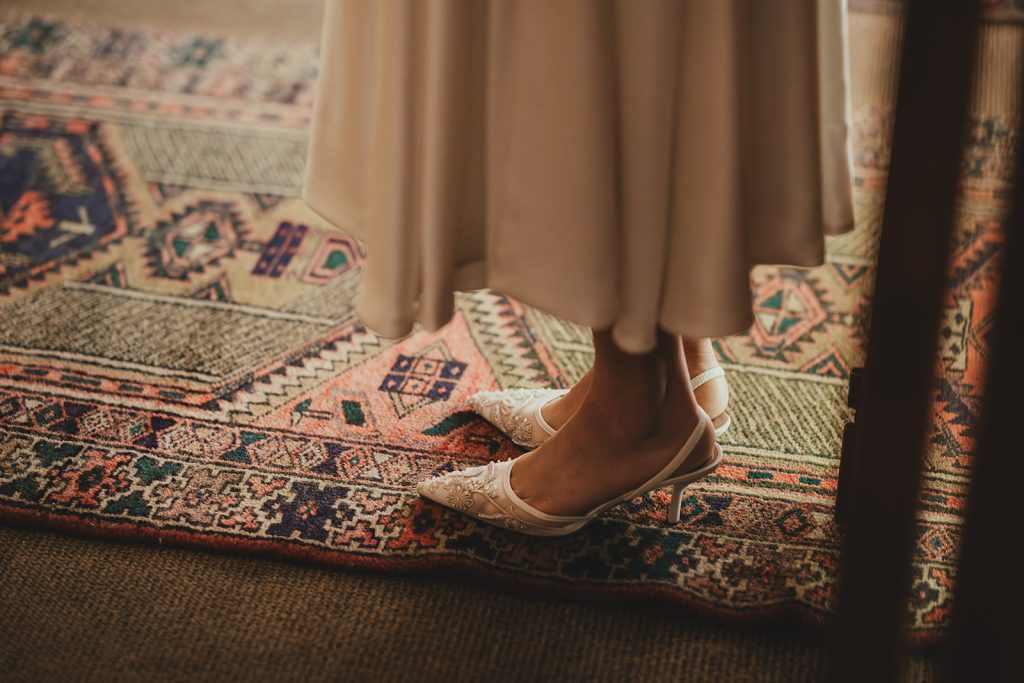 A detail photo of the bride's wedding shoes while she's wearing them