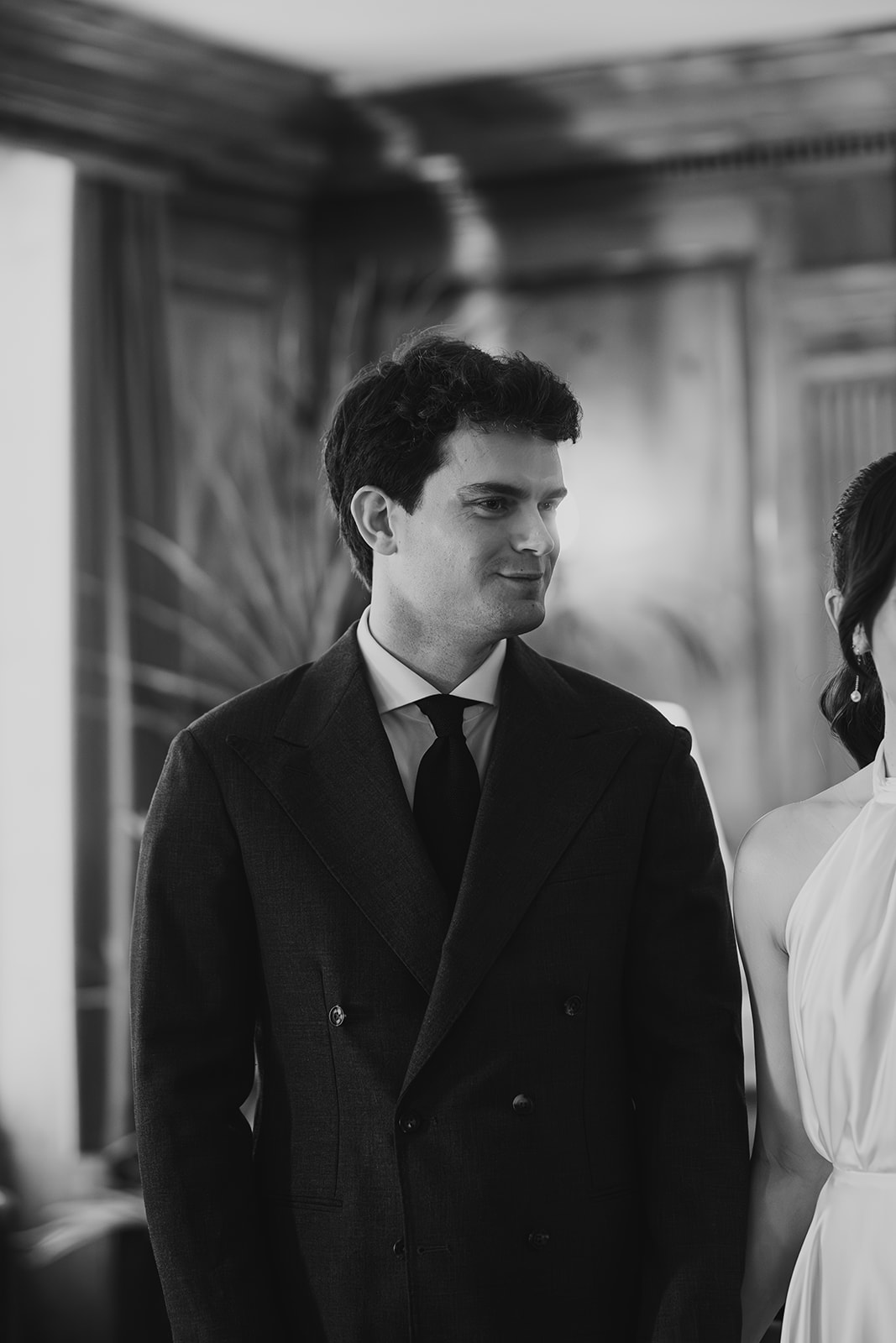 Black and white groom portrait during wedding ceremony