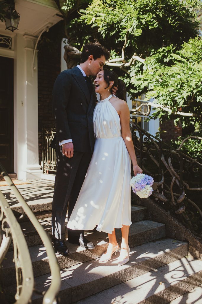 Groom kissing brid on the steps up to the front door of Burgh House