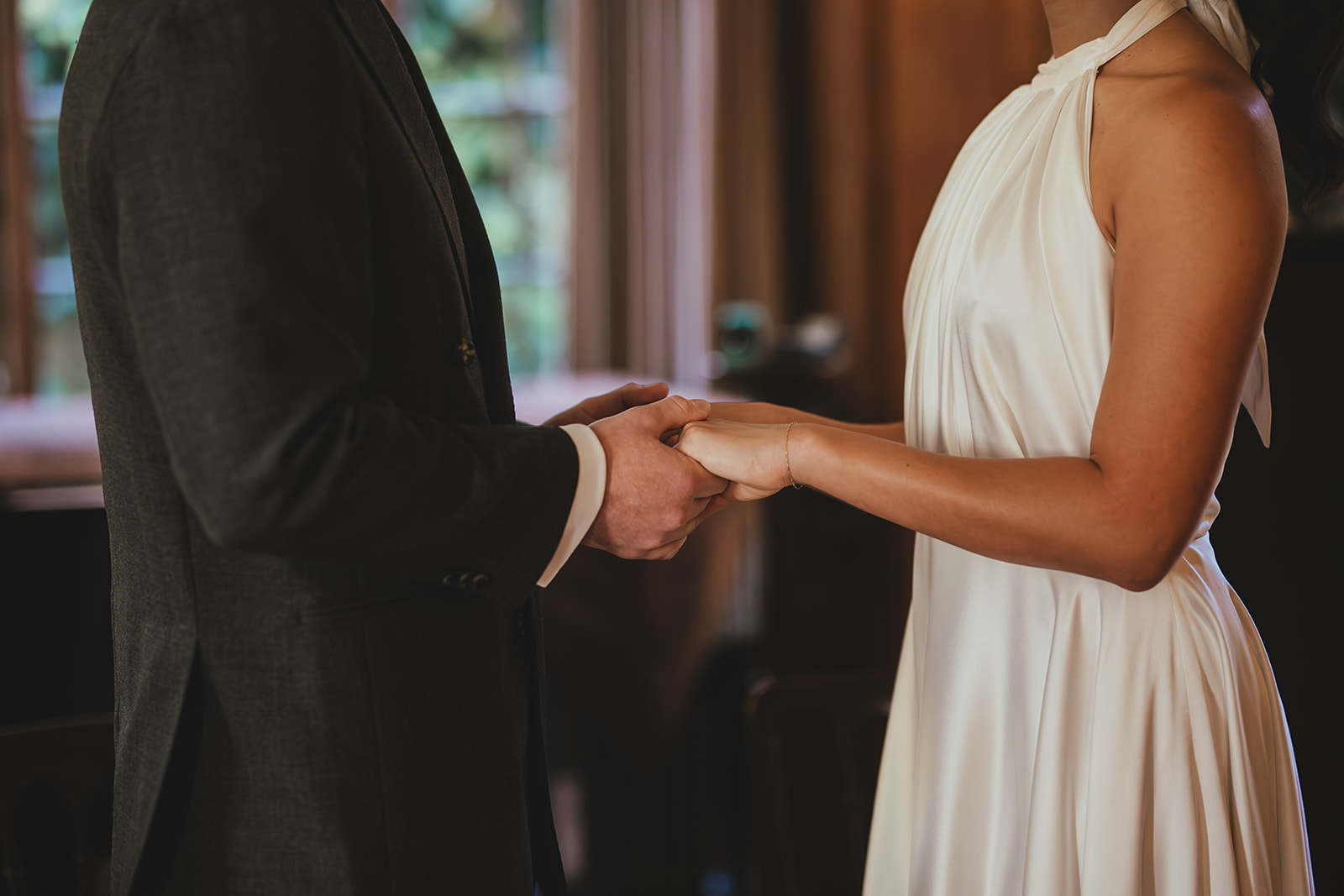 Bride and groom holding hands during their wedding ceremony at Burgh House