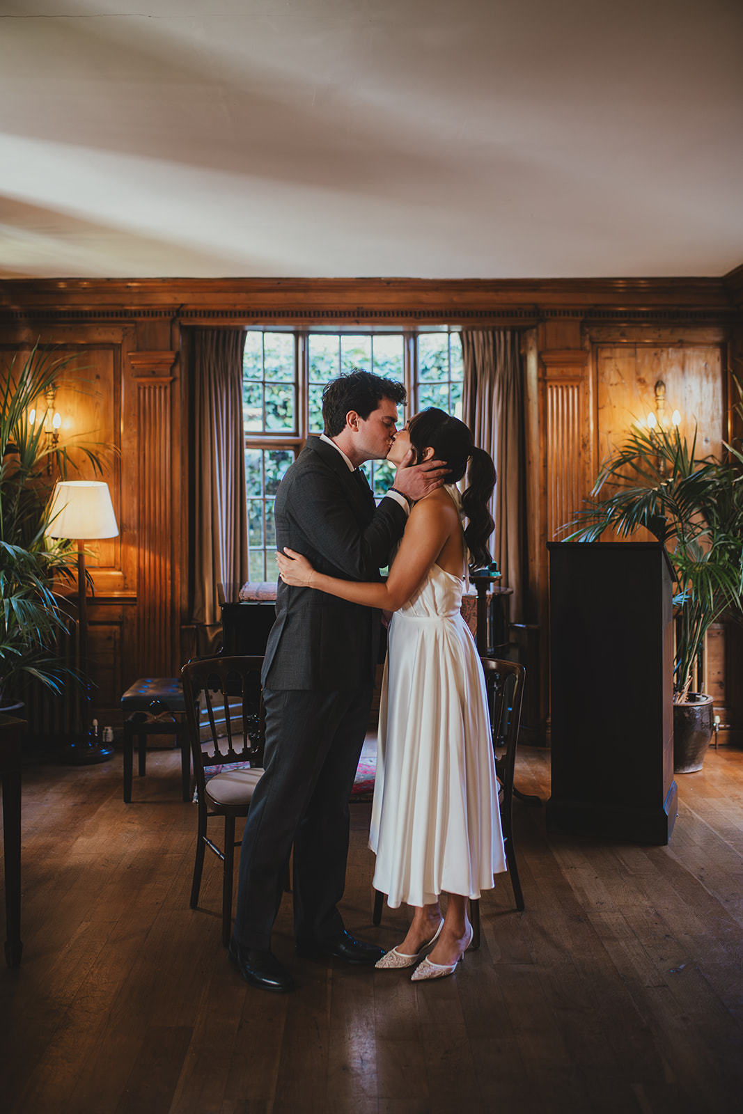 Bride and groom's first kiss after wedding ceremony in the music room at Burgh House