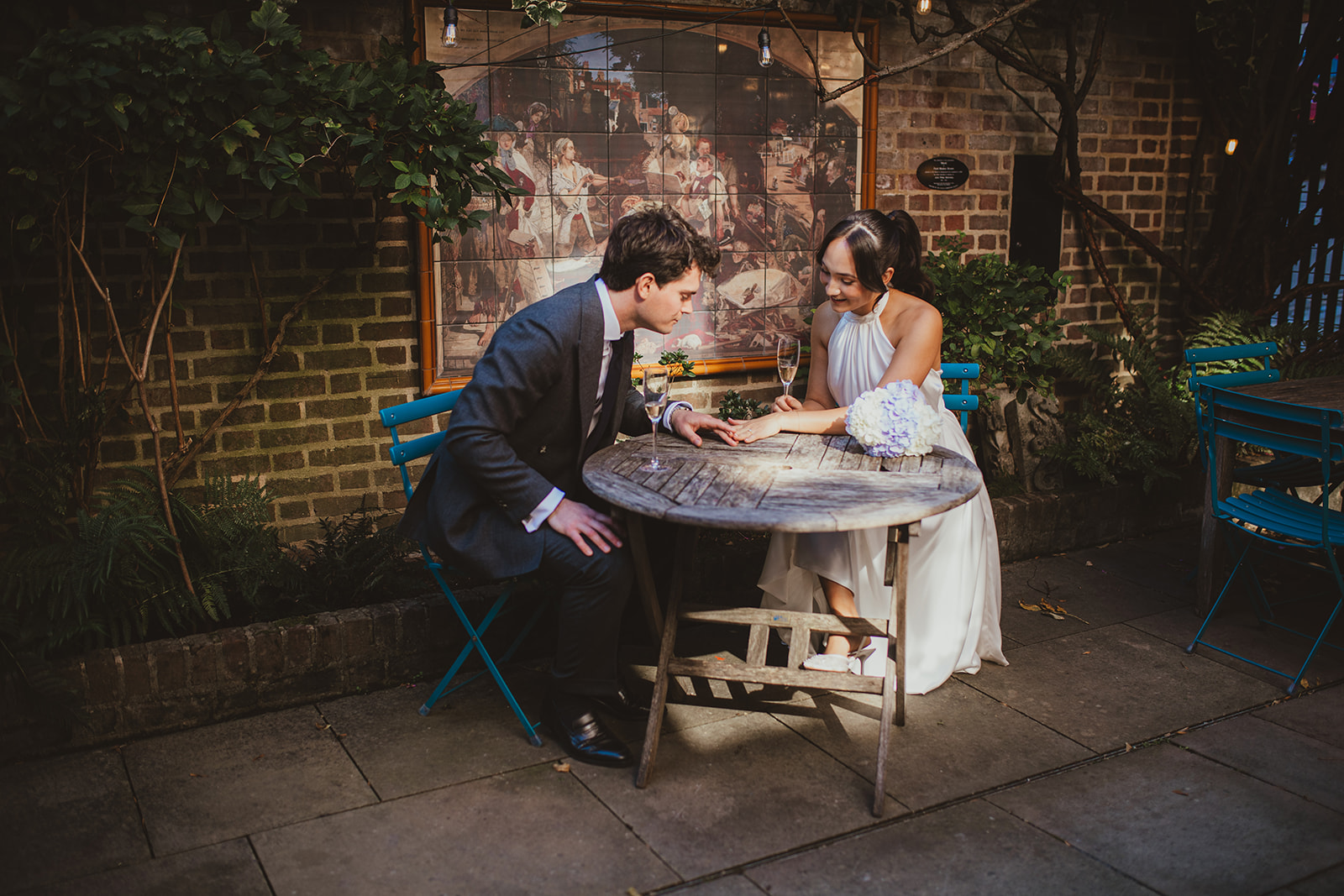 Bride and groom sitting together in the courtyard of Burgh House
