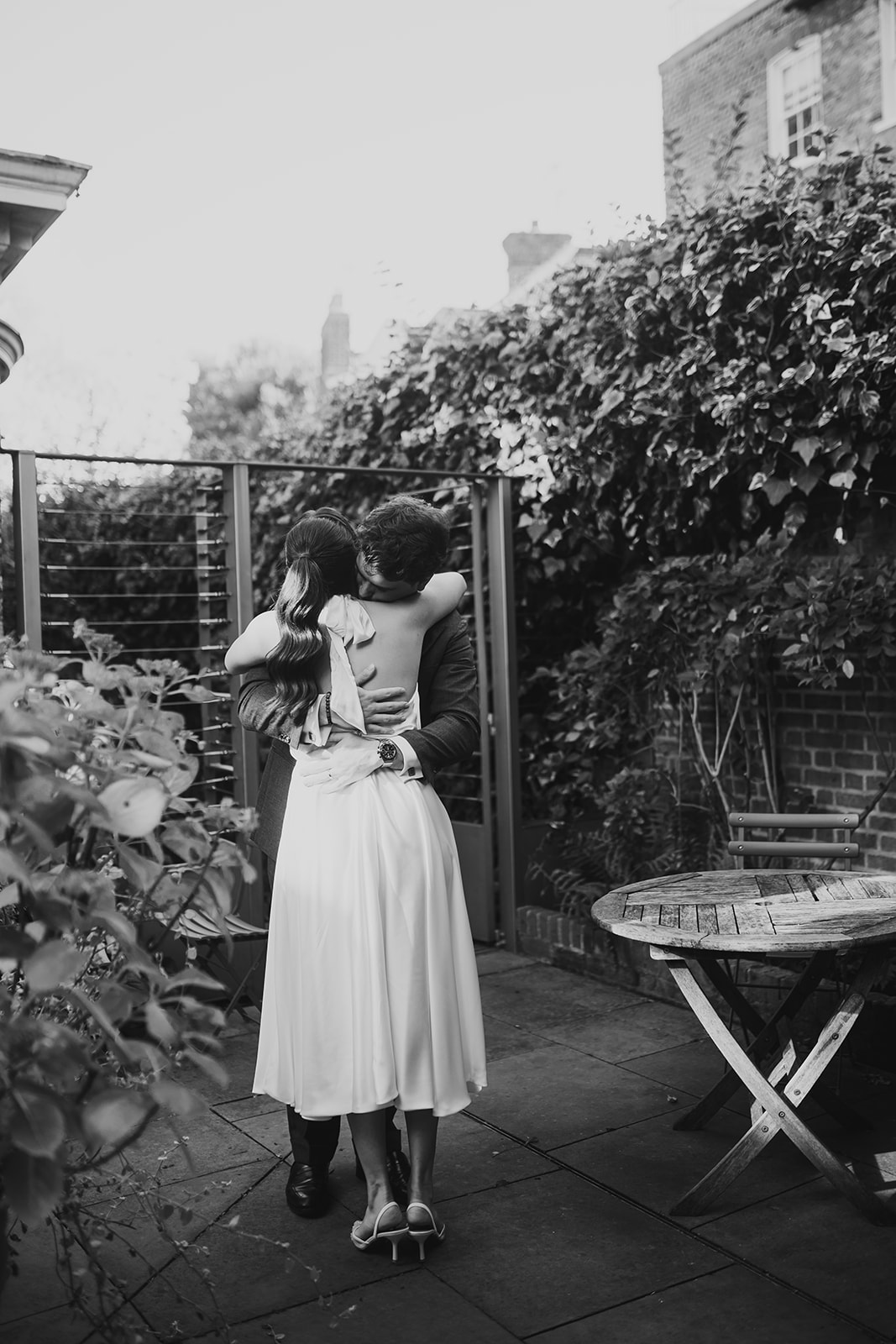 Black and white photo of bride and groom hugging 