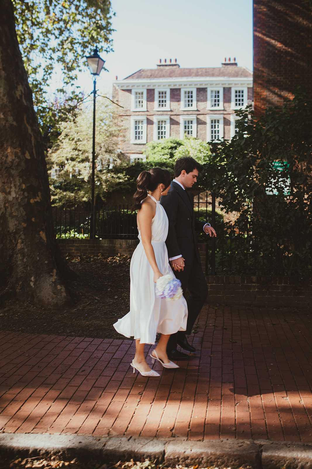 Bride and groom walking past Burgh House together